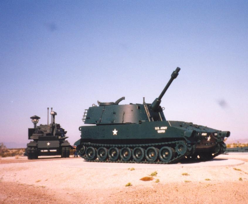 An M247 sits behind an M108 105mm self-propelled howitzer at Yuma Proving Grounds,Arizona. (Photo: Mark Holloway, CC BY 2.0)